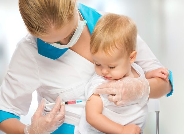 Медсестра делает прививку ребенку от гриппа